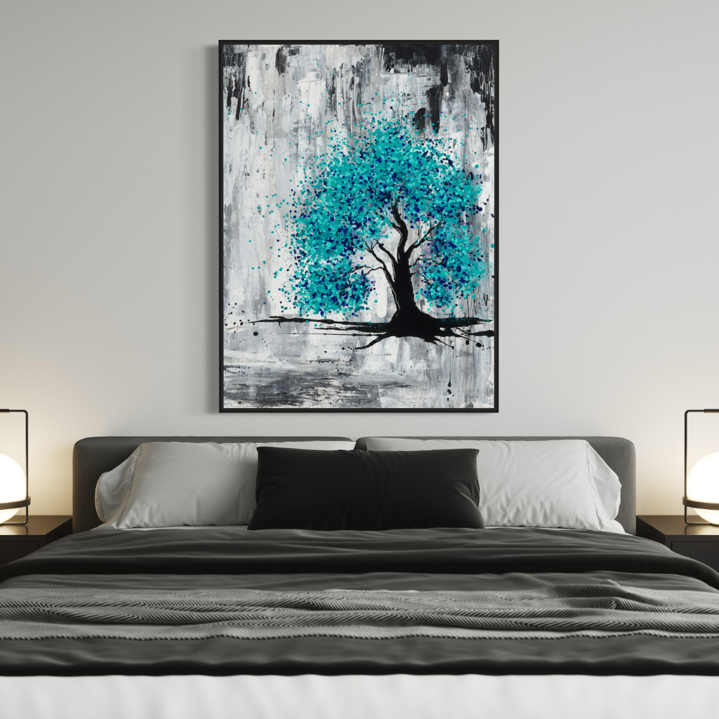 A framed canvas print with black frame, burst of blue on a grey and charcoal background, perfectly captures hope in darkness. A perfect addition to fill positivity in any space. Displayed on an egg white wall with dark grey cushion and quilt cover on bed..